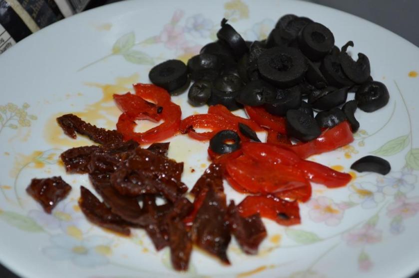 Sliced olives, bell peppers and dried tomatoes.